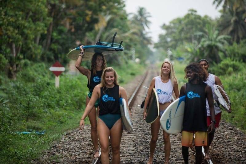 Surfers carrying their boards along the railway line to Weligama Bay, The Surfer surf camp, Sri Lanka